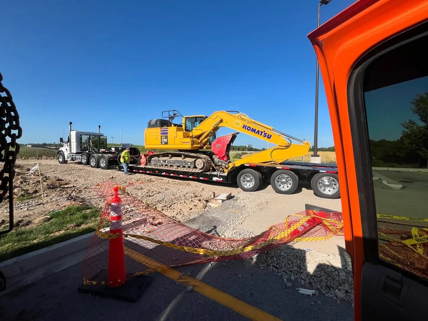 Yellow Komatsu excavator secured on a transport trailer